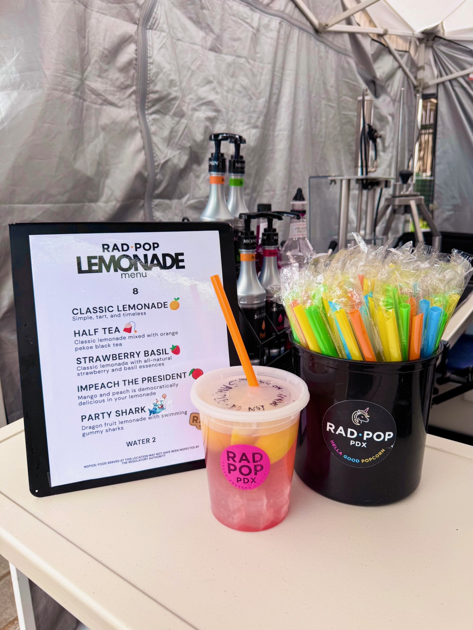 Close-up of the Rad Pop lemonade menu and a bright pink lemonade